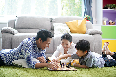family playing chess on the floor