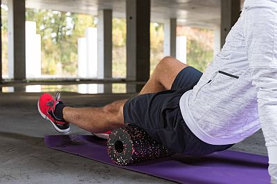 man stretching with a foam roller