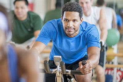 young man on exercise bike in fitness class