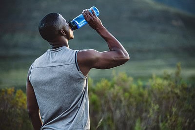 athlete drinking from a water bottle hydration
